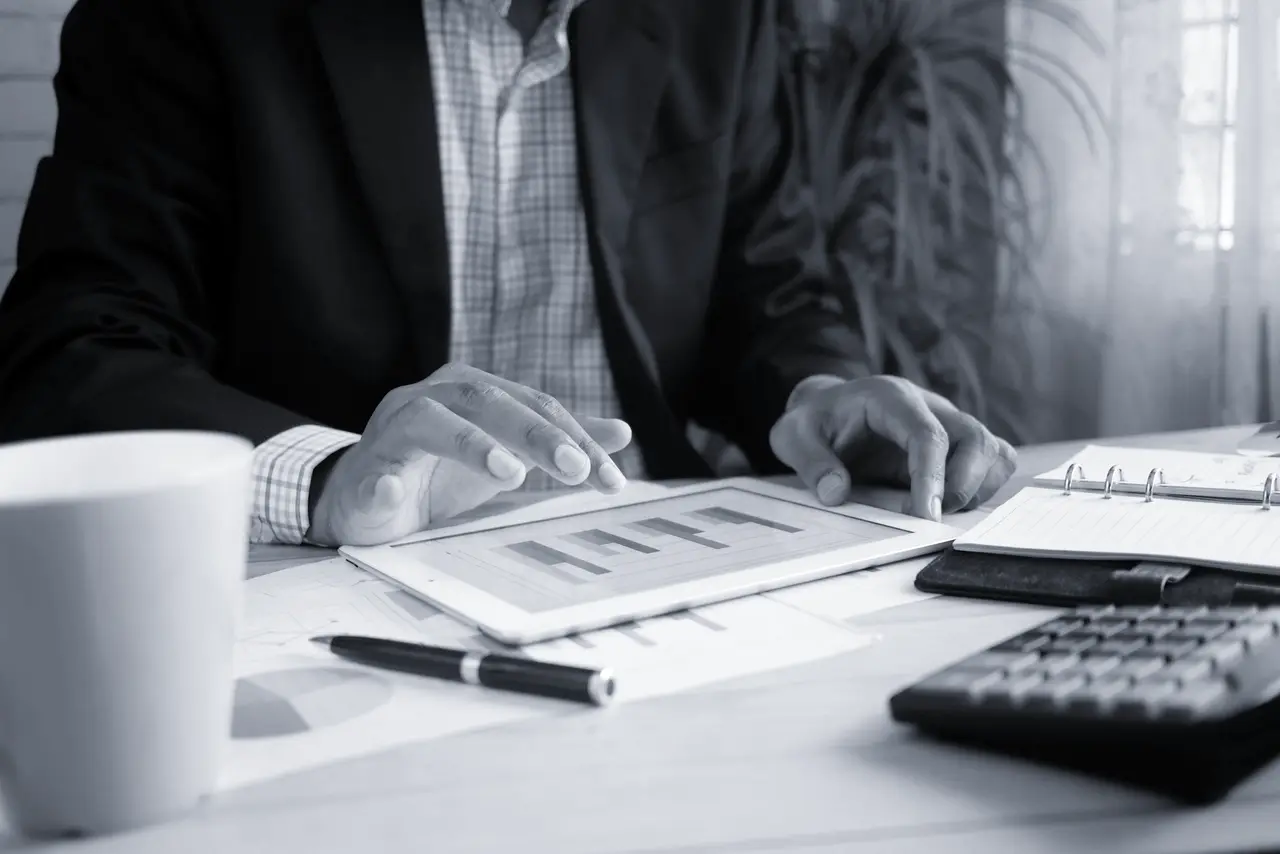 A professional reviewing printed financial charts at a desk