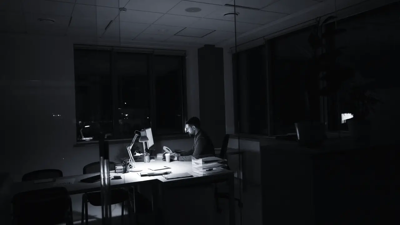A lone analyst working late in a darkened office